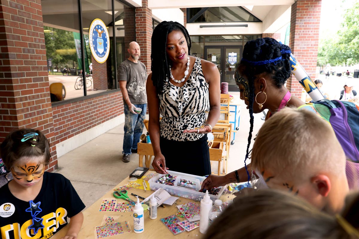 Pres. Dr. Manya Whitaker bedazzles sunglasses and chats with others on July 22 during CC Day for DoD Warrior Games on campus. Photo by Jamie Cotten / Colorado College